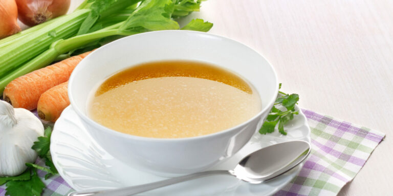 Bowl,Of,Broth,And,Fresh,Vegetables,On,Wooden,Table